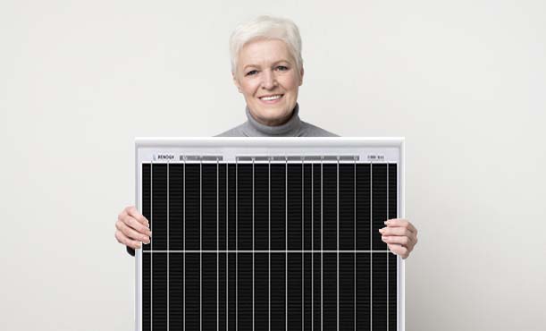 Ältere Dame hält ein Photovoltaikmodul