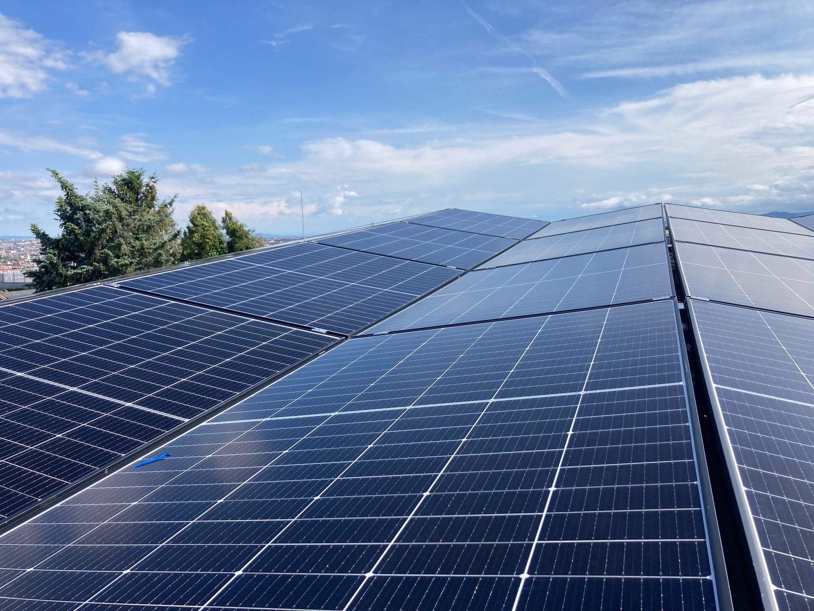 Photovoltaikmodule auf einem Dach vor dem Stadthorizont