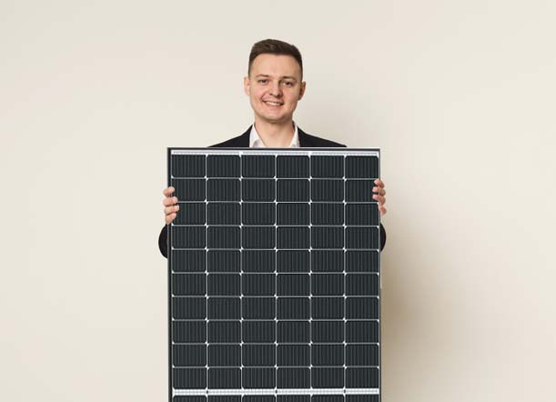 Junger Mann mit Photovoltaikmodul in den Händen