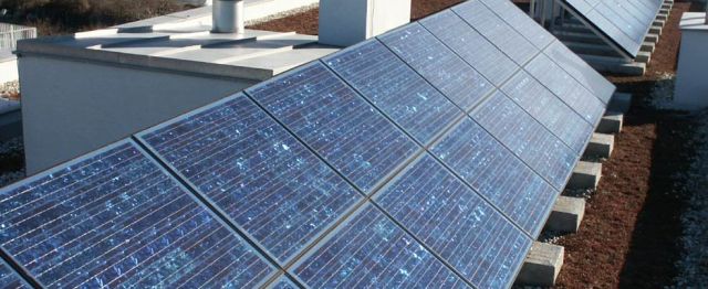 Photovoltaikanlage auf dem Flachdach eines Mehrparteienhauses